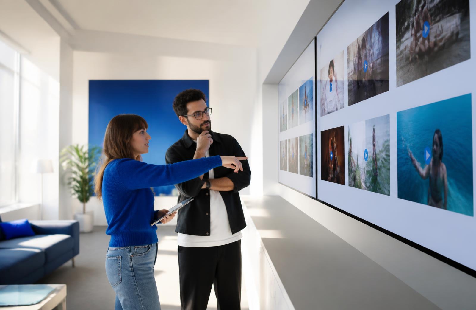 Media- und Kreativteam vergleicht mehrere Videoanzeigen auf großen Bildschirmen
